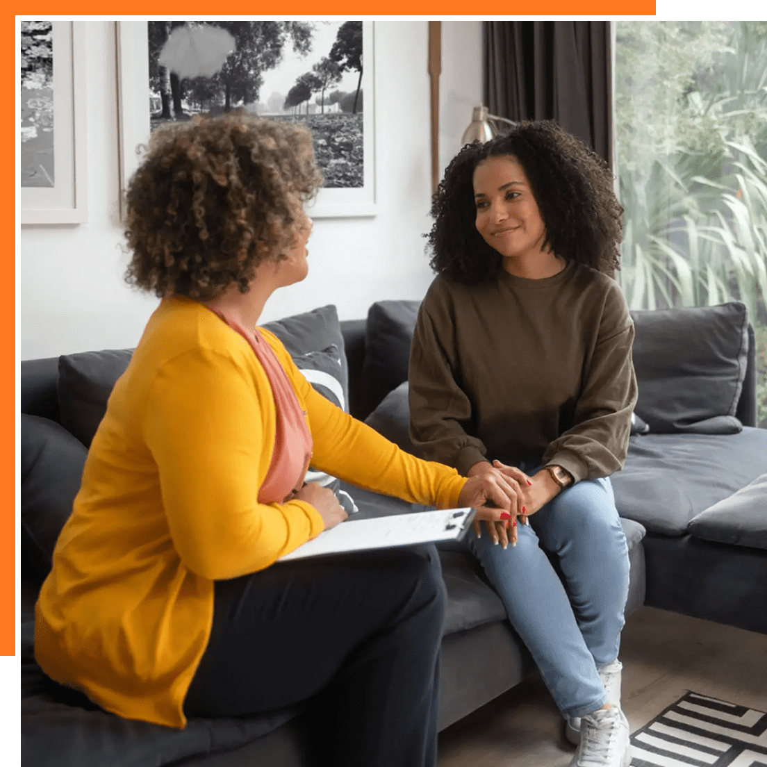 Two women having a heartfelt conversation in a cozy living room.