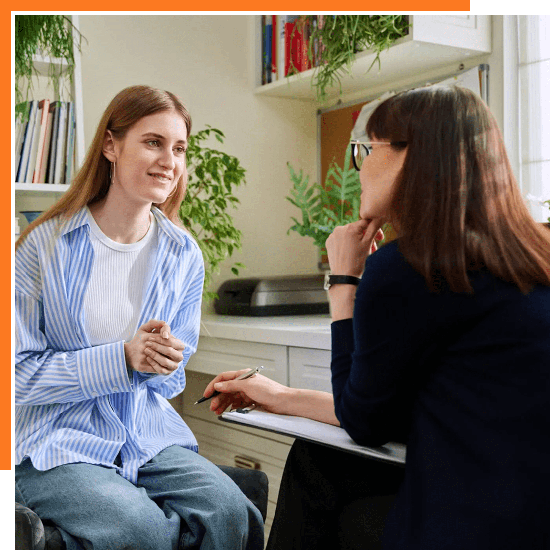 Two women engaged in a friendly conversation in a cozy room.