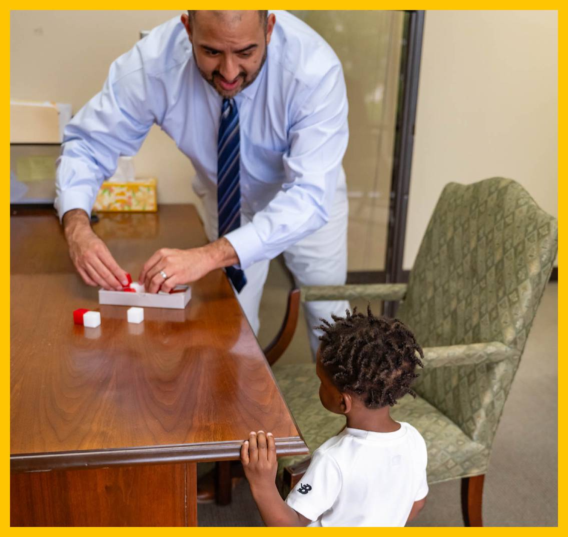 Man playing a game with a child at a table.